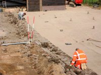 Het leggen van de klinkerkei op de zand / puinfundatie.